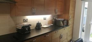 a kitchen with a counter with a toaster and a microwave at 18 Sea View Close in Scarborough +23 photos