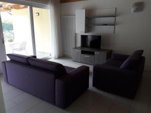 a living room with two couches and a tv at Casa Magosta in Malcesine