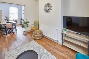 een woonkamer met een tv en een tafel en stoelen bij Host & Stay - Clifton House in Scarborough
