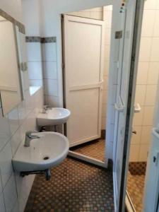 a bathroom with a sink and a mirror and a door at Baltic Home in Polanica-Zdrój