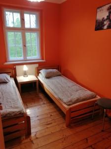 a bedroom with two beds and a window at Baltic Home in Polanica-Zdrój