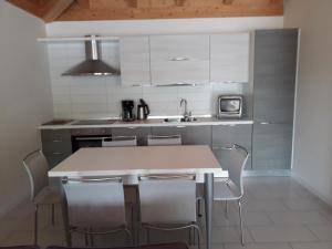a kitchen with white cabinets and a table and chairs at Casa Magosta in Malcesine