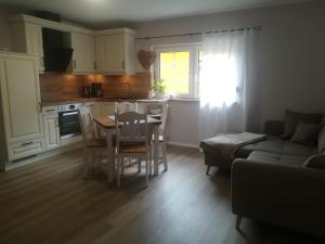 a kitchen and a living room with a table and chairs at Landhaus Huchatz in Burg