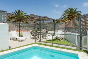 a patio with a table and chairs and a swimming pool at Casa La Huertecilla in La Sorrueda