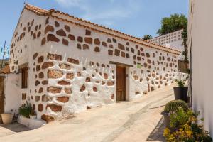 a building with a stone wall with a door at Casa La Huertecilla in La Sorrueda