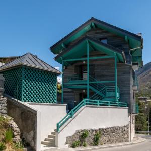 a wooden house with a green roof and stairs at LES CHARMETTES in Brides-les-Bains
