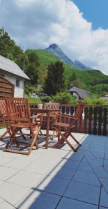 2 chaises en bois et une table en bois sur la terrasse dans l'établissement Gostišče Hedvika, à Kal-Koritnica