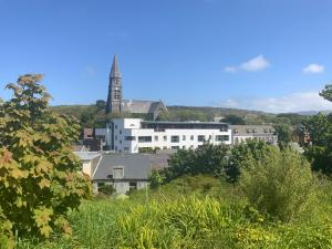 a building with a clock tower in the distance at Courthouse View Penthouse in Clifden