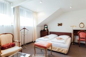 a bedroom with two beds and a chair at Das Kleine Hotel in ruhiger Stadtlage in Wiesbaden