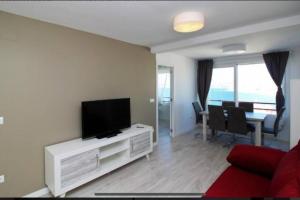 sala de estar con TV de pantalla plana en la pared en Dori Seaview Apartment, en Benidorm