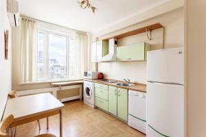 a kitchen with a white refrigerator and a table at ApartLux Novoarbatskaya Superior 2 in Moscow