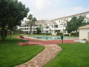 - une piscine avec un banc dans la cour dans l'établissement Chalet adosado en urbanización con precioso jardín, à Dénia