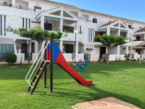 - une aire de jeux dans une cour avec toboggan dans l'établissement Chalet adosado en urbanización con precioso jardín, à Dénia