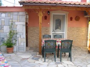 - une table et des chaises sur une terrasse à l'extérieur de la maison dans l'établissement AGERI STUDIOS, à Skala Kallirakhis