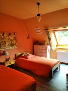 - une chambre avec des murs orange, un lit et une fenêtre dans l'établissement Maison dans un environnement boisé très calme, à Morlaix