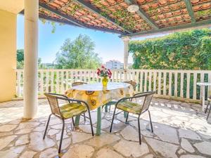 einen Tisch und Stühle auf einer Terrasse mit einem Zaun in der Unterkunft Apartment in Medulin with Terrace, Air conditioning, Wi-Fi (4634-5) in Medulin