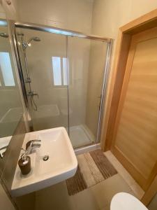 uma casa de banho com um lavatório e um chuveiro em Hepburn Holiday Apartment em Birżebbuġa