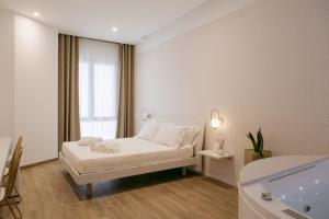 una camera da letto bianca con un letto e una finestra di Porta D'Oro Charming House ad Alghero
