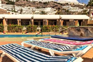 two lounge chairs sitting next to a swimming pool at Leticia del Mar Adults Only in Puerto Rico de Gran Canaria