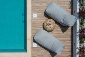 2 almohadas en el suelo junto a la piscina en Villa Verde, en Kallithea