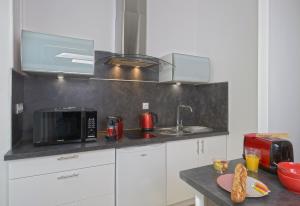 a kitchen with white cabinets and a black counter top at Hyper Centre Rue Valdemaine in Angers