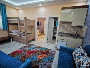 a room with a couch and a kitchen and a bunk bed at Kuloğlu Otel ve Restoran in Uzungol