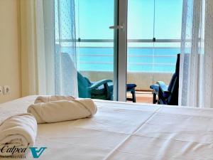 uma cama num quarto com vista para o oceano em Playa de Oro 17C Peñon & Sea View Arenal Beach em Calpe