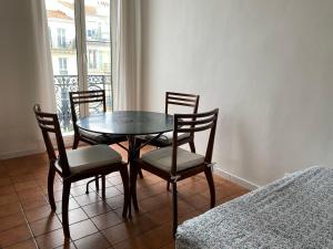 a table and chairs in a room with a window at Studios Floreal in Nice