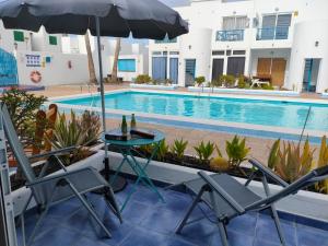 a table and chairs next to a swimming pool at BLU in Puerto del Carmen