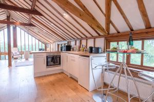 a kitchen with white appliances and wooden ceilings at The Hayloft Clopton Air Manage Suffolk 
