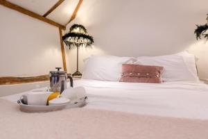 a tray of food on top of a bed at The Hayloft, Clopton in Clopton