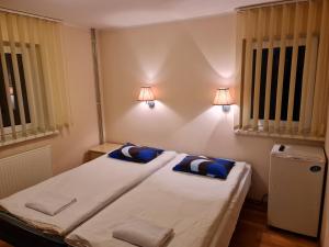 a bedroom with a bed with two pillows and two windows at Felixi Maja in Viljandi