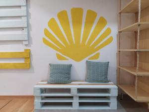 a yellow flower on a wall with two pillows at Albergue O Peirao in A Guarda