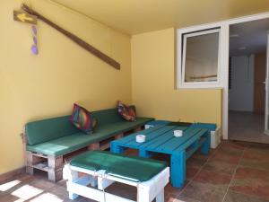 a room with two benches and tables and a window at Albergue O Peirao in A Guarda