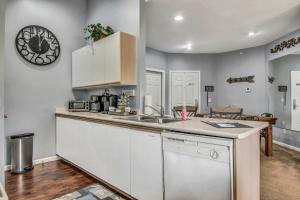 uma cozinha com um lavatório e um relógio na parede em Hollowed Branch Hideaway Condo em Branson