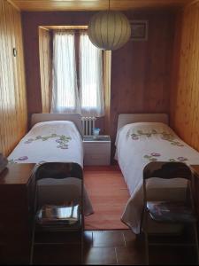 a bedroom with two beds and a table and a window at La casa rosa in Sernio +29 photos