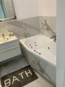 y baño con lavabo y bañera. en Apartment Kaczorowskiego 14 en Białystok