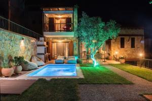 a house with a pool in the yard at night at Dandy Villas Nea Roda - Melodic Waves - Private - Pool - Parking - Cellar in Nea Roda