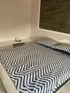 a bed with a black and white comforter on it at Apartment Kaczorowskiego 14 in Białystok