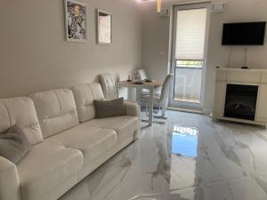 a living room with a white couch and a table at Apartment Kaczorowskiego 14 in Białystok