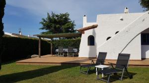 a group of chairs sitting on a deck in front of a building at Acacies 25 in Torroella de Montgrí