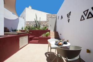 a small balcony with a white table and chairs at Domus Hestia Suites in Pirgos