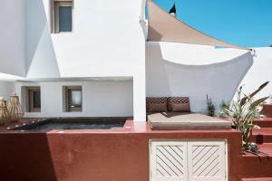 a patio with a bed and a building at Domus Hestia Suites in Pirgos