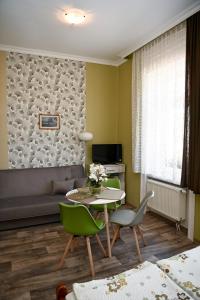 sala de estar con mesa, sillas y sofá en Angéla Vendegház en Tokaj