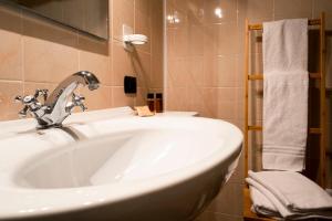 uma casa de banho com um lavatório branco e um espelho. em Eremo della Gasprina em La Morra