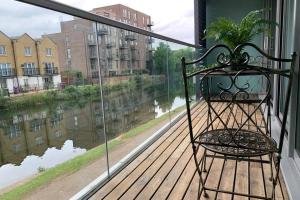 a chair on a balcony with a view of a river at Regents Casa in London