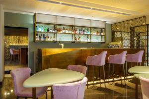 インターラーケンにあるHotel Du Nordのピンクの椅子とテーブルのあるバー