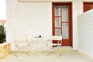 two chairs and a table on a patio at Filoxenia Studios 1 in Palaiochora +4 photos