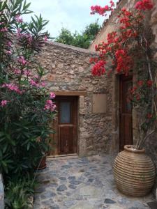 a stone building with a vase with flowers in front of it at Athina Guesthouse in Monemvasia