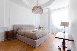 a white bedroom with a bed and a lamp at Coste Investissement - Le grand standing in Marseille